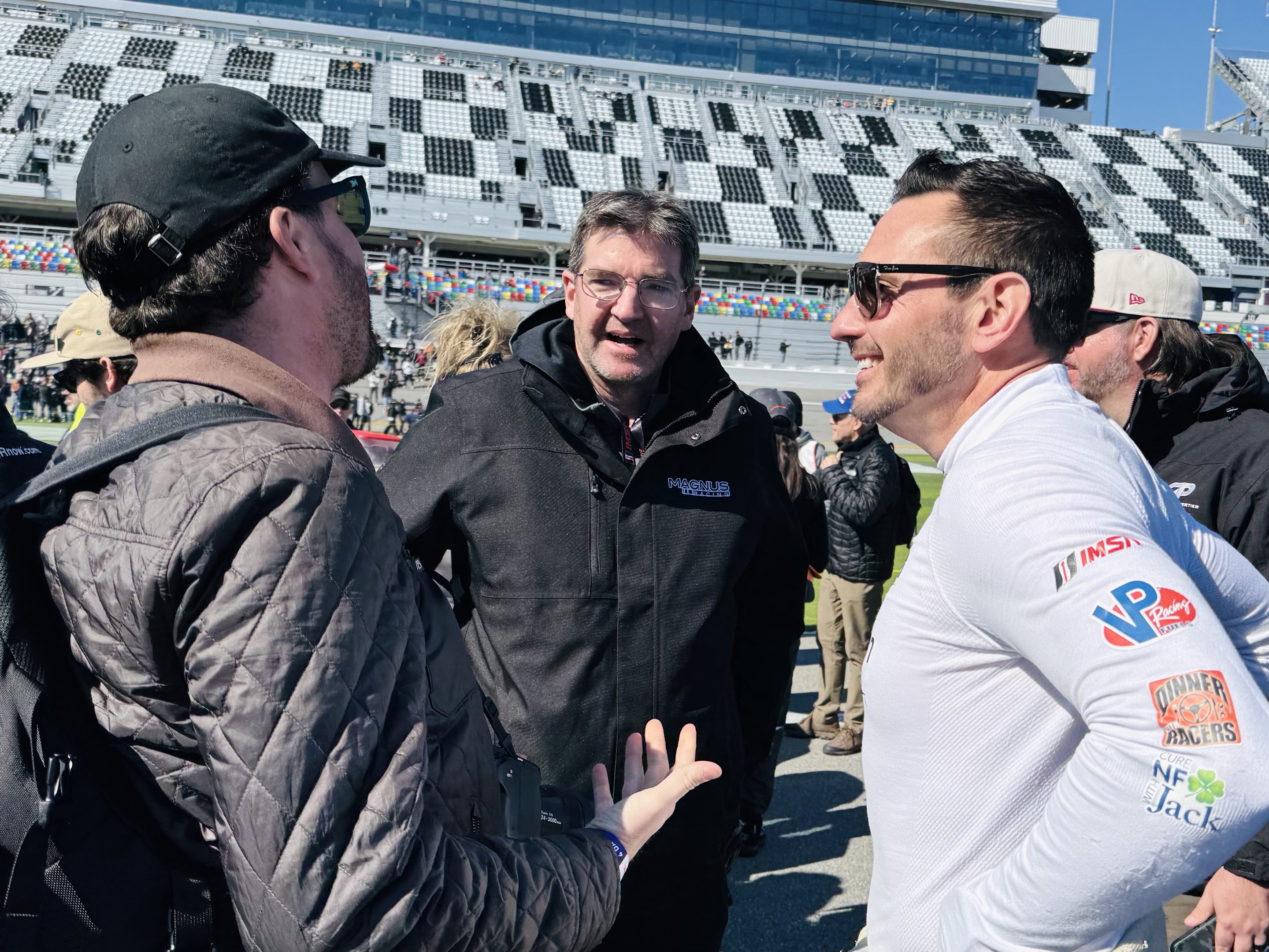 Men yapping next to race cars